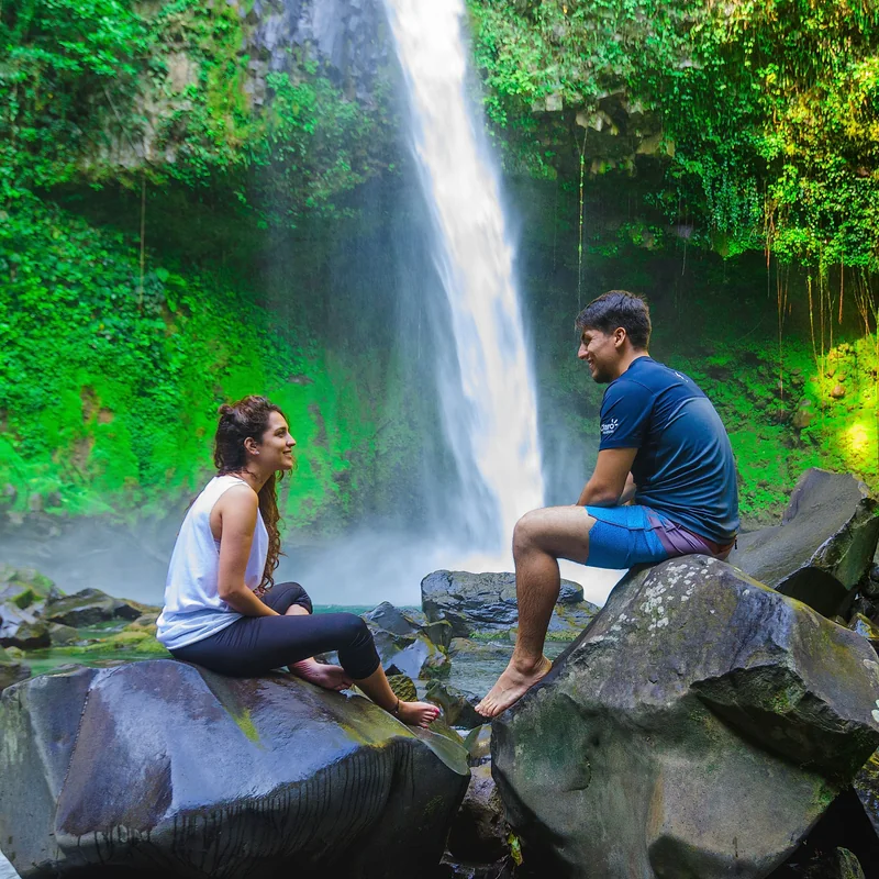 Tourists enjoying a refreshing swim at the base of the La Fortuna waterfall.