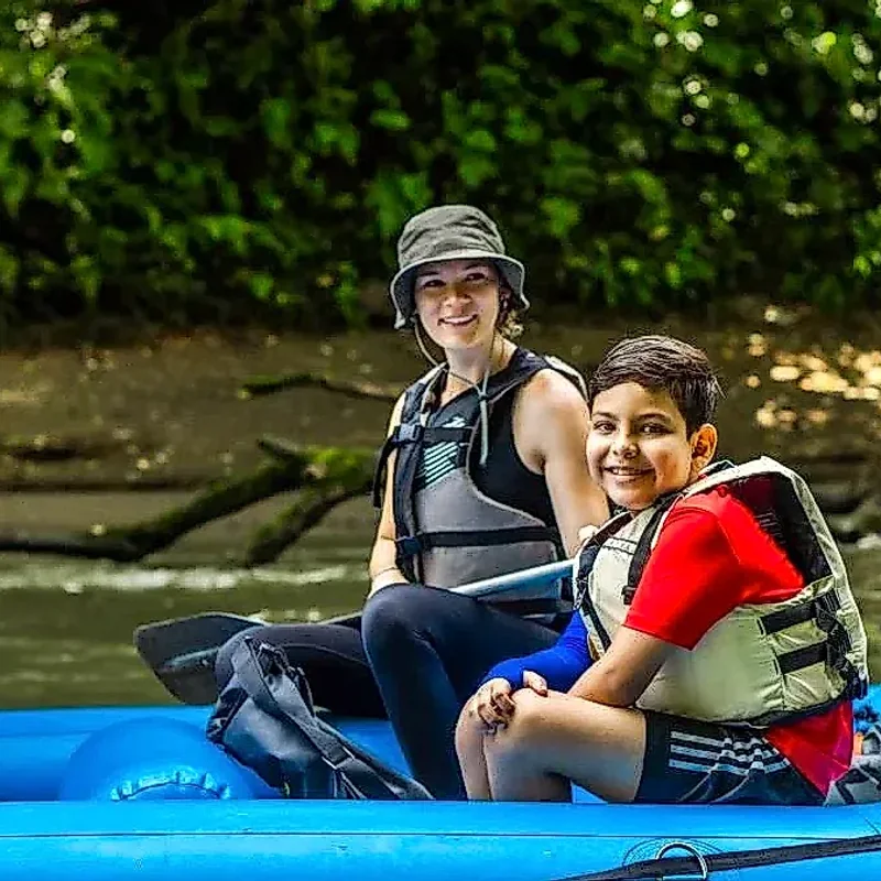 Tourists observing nature from a boat on the San Carlos River, an eco-friendly experience.