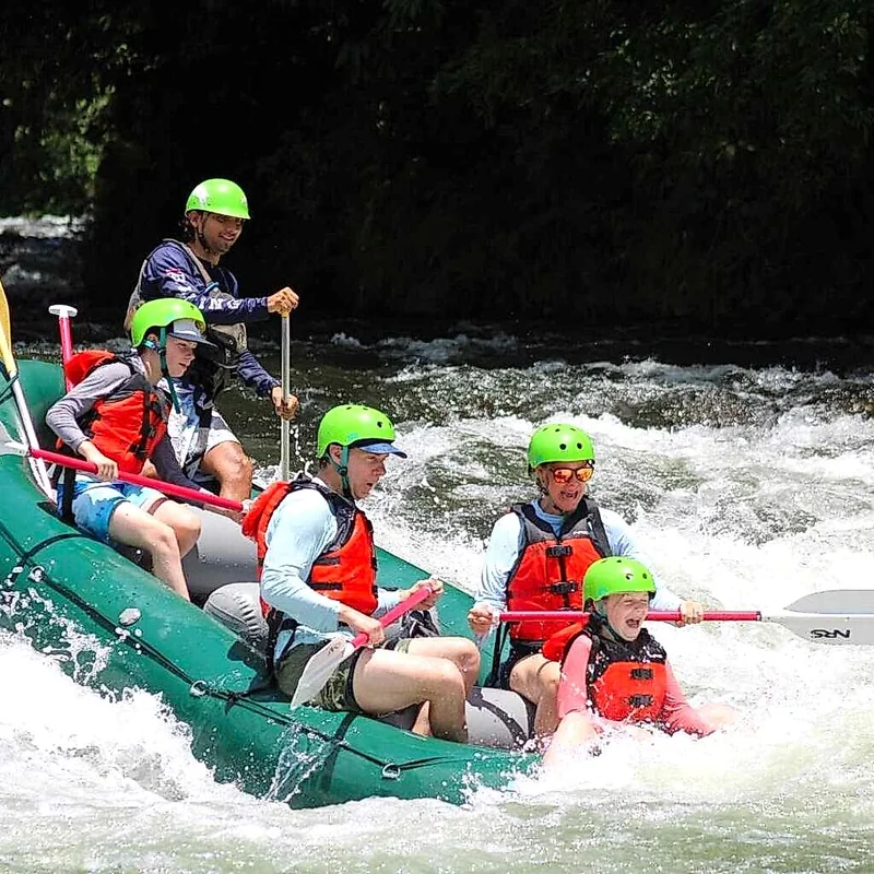 Group of adventurers navigating class III rapids on the Sarapiquí River, Costa Rica.